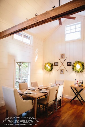 Dining room with vaulted ceilings, shiplap walls, and farm table.