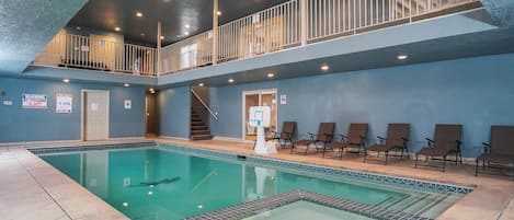 Entertaining indoor private pool and hot tub with upper balcony