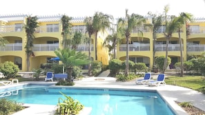 Pool, gardens, and apartment building.