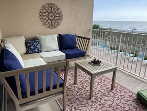 Comfy cozy balcony seating with thick foam cushions overlooking pool and ocean — new cushions April 2022.