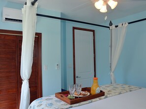 Four poster bed in one bedroom villa, showing reach in clothes closet.