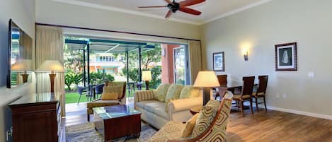 living area, wall mounted 65" 4k TV, wood tile flooring.