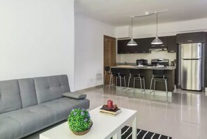 The livingroom comes with an open fully equipped kitchen, balcony, seating area,