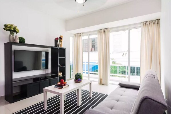 The livingroom comes with an open fully equipped kitchen, balcony, seating area,