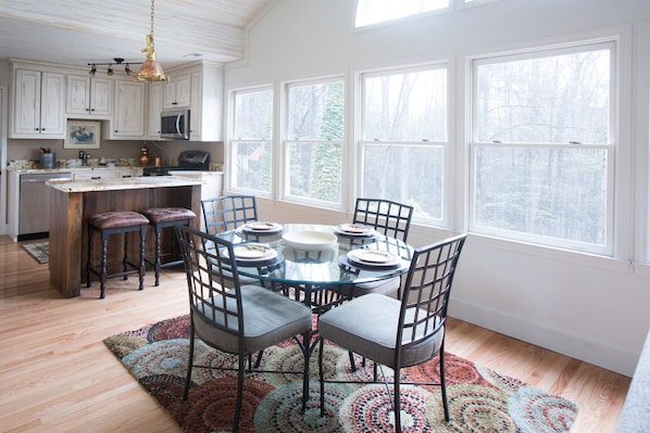 Dining area with vaulted ceilings and tons of light overlooking the beautiful, natural yard.