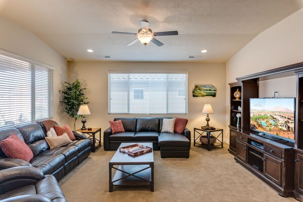 Spacious open concept family room with large TV and sofas