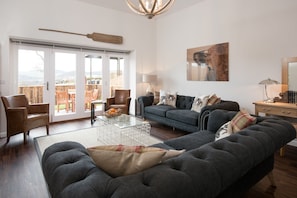 Byre - sitting room with bi-folding doors to garden