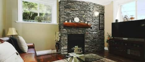 Front living room with floor to ceiling rock fireplace.