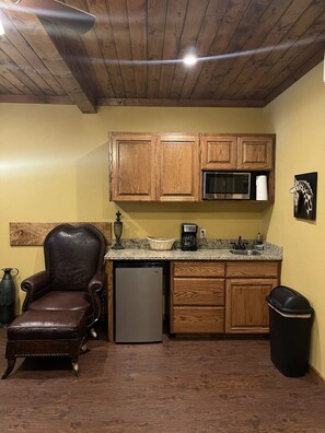 Kitchenette with mini fridge, coffeemaker, microwave and bar sink.