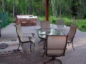 pepple deck with hot tub seats 6, fenced yard, veiw of forest