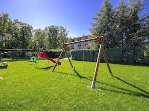 Swing, Playground, Outdoor Play Equipment, Public Space, Grass, Sky, Human Settlement, Tree, Lawn, Land Lot