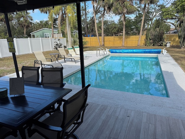 Fully fenced in yard with covered patio and refreshing pool.