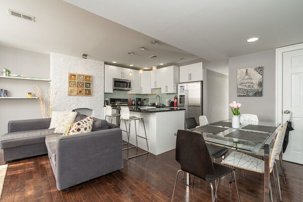 living room, dining area, and kitchen with breakfast bar
