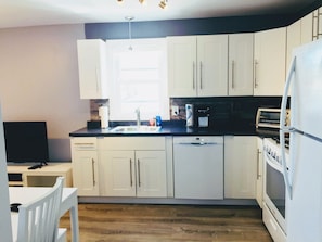 kitchen area w/ dishwasher, oven/stove, fridge & Keurig