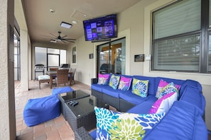 Patio Seating and Dining area with 65in TV and High Powered Fans