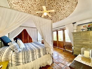 Master bedroom includes a king size bed, ceiling fan, balcony, and bathroom