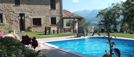 foto d'insieme della villa con piscina in un pomeriggio soleggiato..