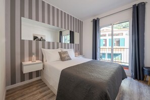 Quarto de dormir com cama de casal e acesso à varanda