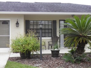 Front of home with 2 Adirondack chairs and table. 