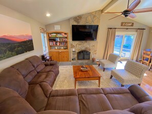 Living/Dining Area: Beautiful open concept space with large dining table that seats 10 and modern, comfortable furniture that surrounds the impressive stone fireplace.