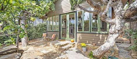 Front Courtyard with sitting area surrounded by trees and flowers. 