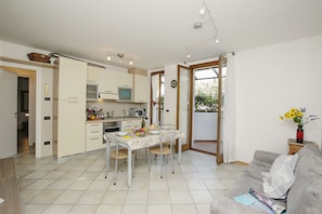 Living area with kitchen, dining table and sleeping sofa