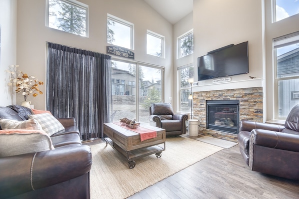 Living Area - Vaulted ceilings, large windows, and sliding door access to the back patio.