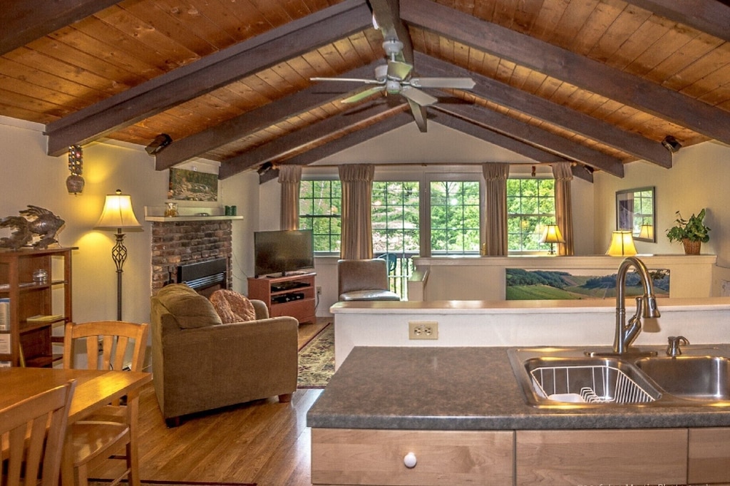 Exposed rafters on the ceiling and a fireplace in a vacation rental near North Conway