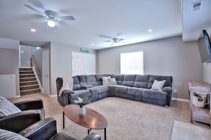 Living room with smart TV, queens size sofa bed, and recliners