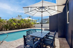 Pool area with seating with umbrella
