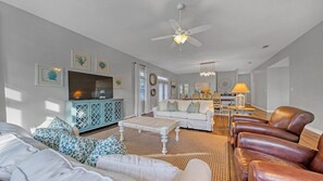 Large open living room with plenty of natural light and smart tv.