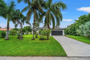 Front yard with palms and trees.
House is protected with ADT.
