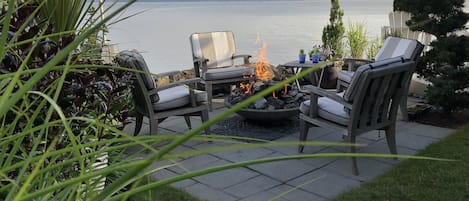 Waterside patio with centrally located fire pit.