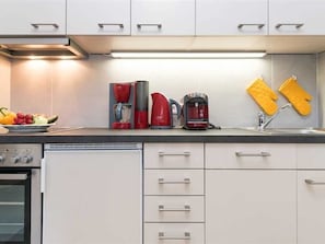 Die moderne Küchenzeile, der Wohnung 5 des Haus Norderhoog in der Kjeirstr. 20, in Westerland, mit Backofen, Herd, Geschirrspüler, Wasserkocher, Kaffeemaschine und Toaster