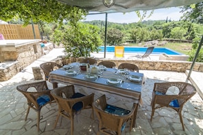 Dining in the shade with view of the pool