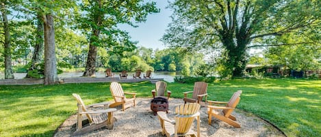 Back yard Oasis! Featuring a wood fire pit and wall right on the rivers edge!