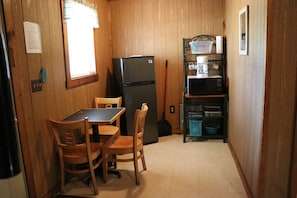 Kitchen nook with refrigerator, microwave, coffee maker, table w/chairs. 