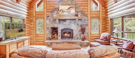 Main living room with floor to ceiling fireplace, flat screen TV