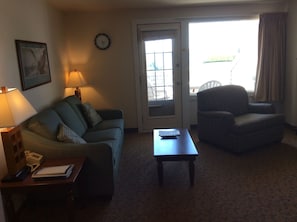 Living room with Queen sofa bed and deck door.