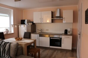 Offene Küche mit Essplatz, Tür zum Schlafzimmer