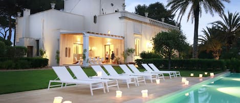 View of the house and portico with dining table for 12, from the pool
