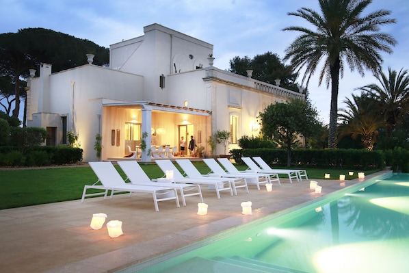 View of the house and portico with dining table for 12, from the pool
