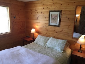 Knotty pine wood walls and cherry nightstands.