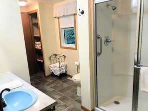 The main bathroom has a stall shower and houses the laundry machines.