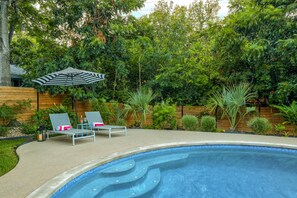 The sparkling pool is surrounded by lush landscaping