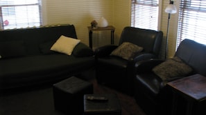 Couch, 2 chairs and hassocks and side tables in living room