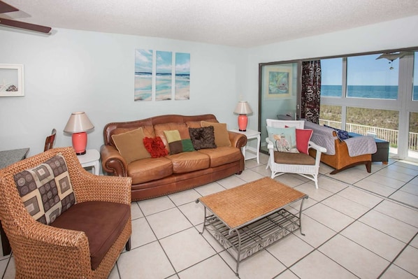 Living room (couch is a sleeper sofa) and enclosed balcony seating with a Gulf view.