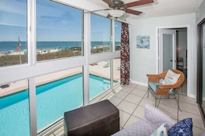 Enclosed balcony with seating overlooking the pool and the beautiful Gulf beaches
