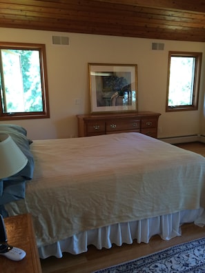 Master bedroom with queen bed and balcony.