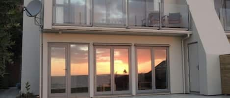 Sunset reflected in beachside bifold doors